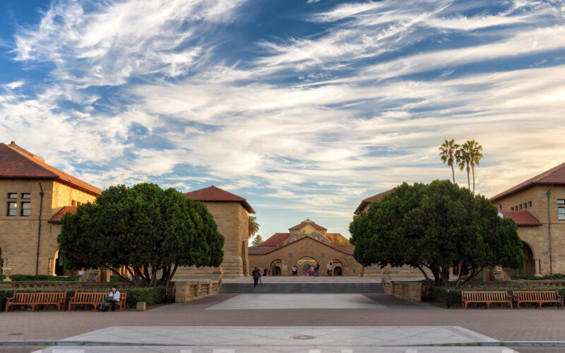Photo of the Stanford University Quad under a blue sky with fluffy white clouds