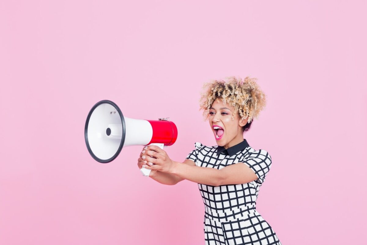 woman in business attire speaks through a megaphone